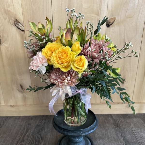 Bouquet of yellow roses and pink chrysanthemums in a glass vase