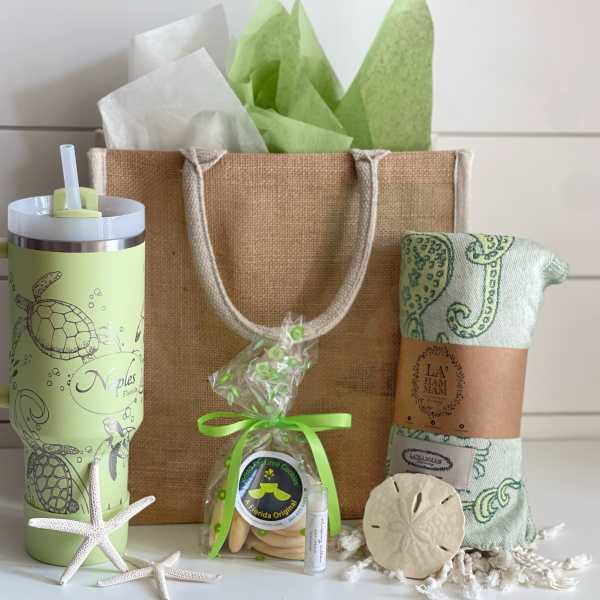 Gift set with a tumbler, tote bag, wrapped blanket, cookies, and starfish decor