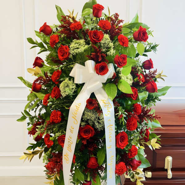 Large red rose funeral spray with white ribbon on an easel