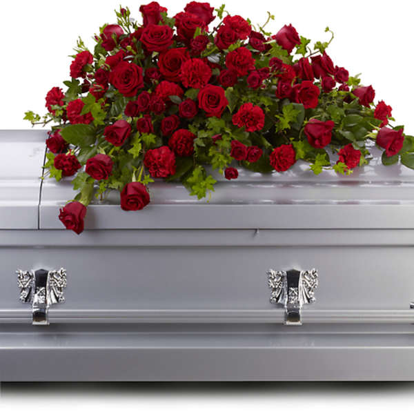 Red rose casket spray with carnations on a silver casket