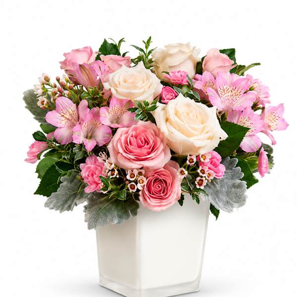 Pink and white rose bouquet in a square glass vase