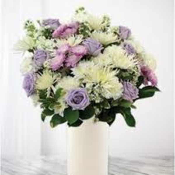 Lavender and white flowers arranged in a white vase