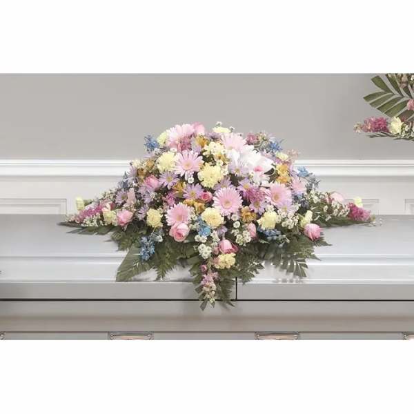 Pastel floral casket spray with pink, white, and yellow blooms