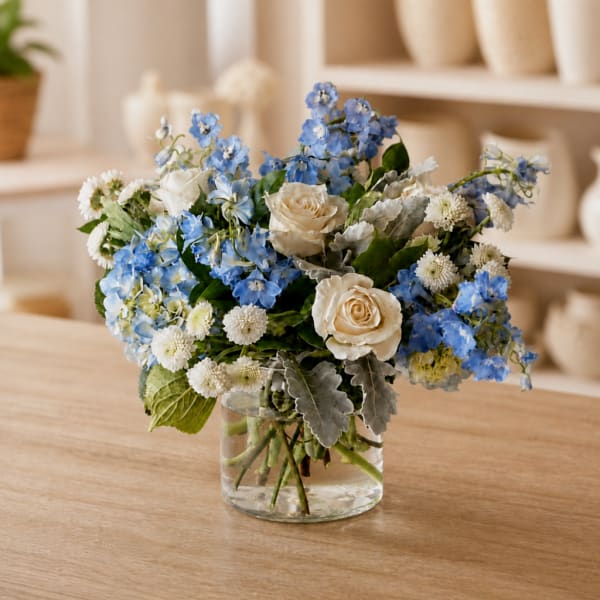 Blue and white flower arrangement in a clear glass vase