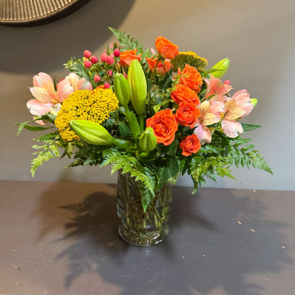 Orange roses and pink alstroemeria in a glass vase