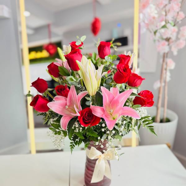 Bouquet of red roses and pink lilies in a vase