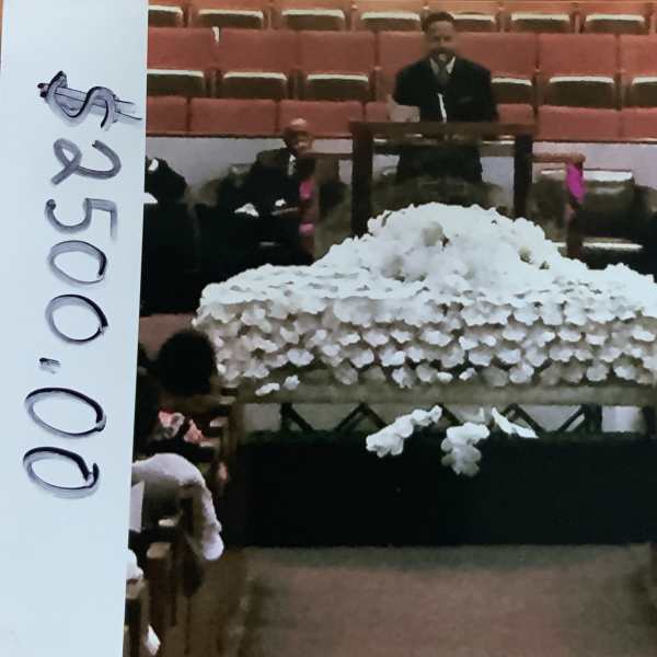 Large white floral casket spray in a church setting