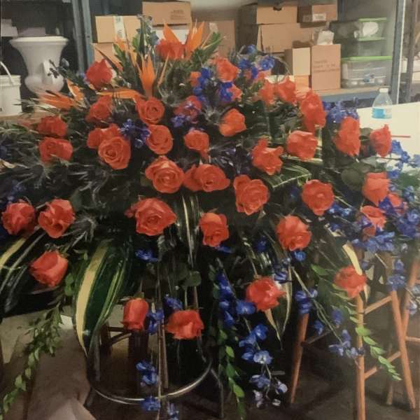 Large floral spray with red roses and blue accents