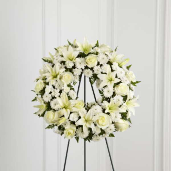 White floral wreath on a black stand