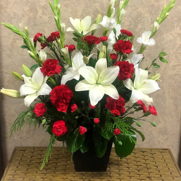 Red carnations and white lilies arranged in a black vase
