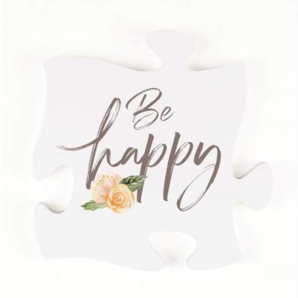 White puzzle piece sign with "Be happy" text and a small floral accent