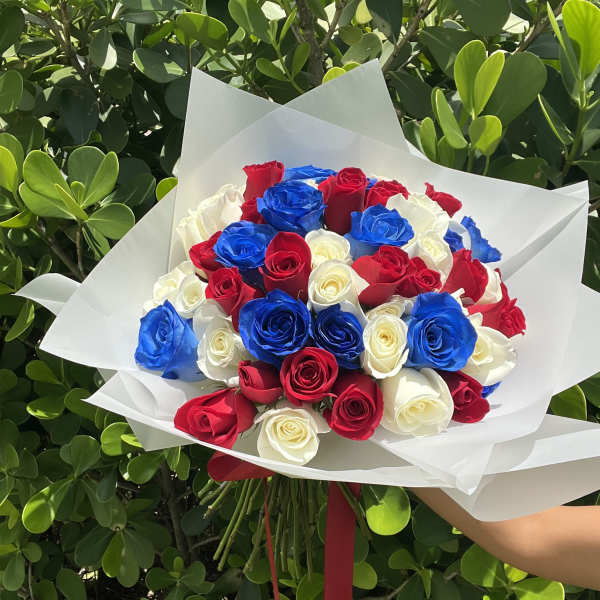 Bouquet of red, white, and blue roses wrapped in white paper