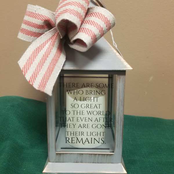 Decorative lantern with a striped bow and memorial quote