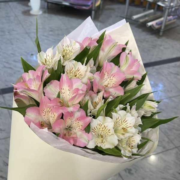 Bouquet of pink and white alstroemeria wrapped in cream paper