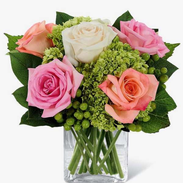 Bouquet of pink, peach, and white roses in a clear glass vase
