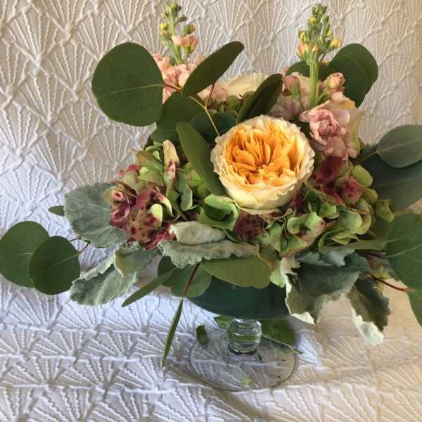 Bouquet of peach and pink flowers in a clear glass vase