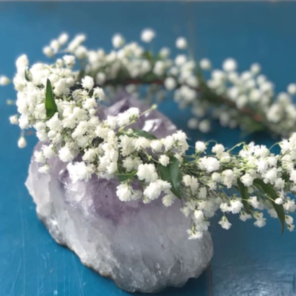 White flower crown resting on a purple crystal