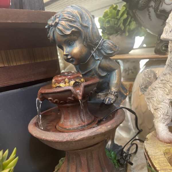 Decorative cherub fountain statue with water flowing into a basin