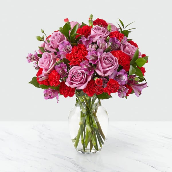 Pink roses and red carnations in a clear glass vase