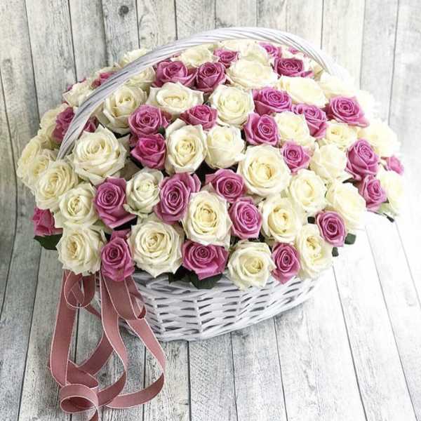 Basket of pink and white roses with a ribbon bow