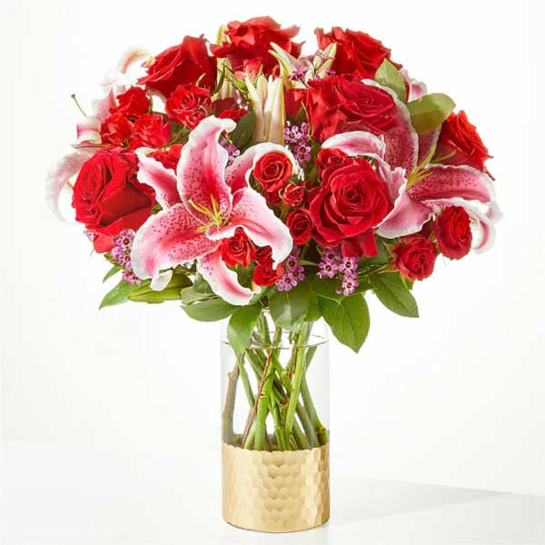 Red roses and pink lilies in a clear glass vase