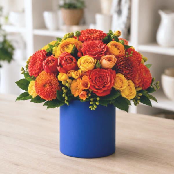Bright orange and yellow bouquet in a blue vase