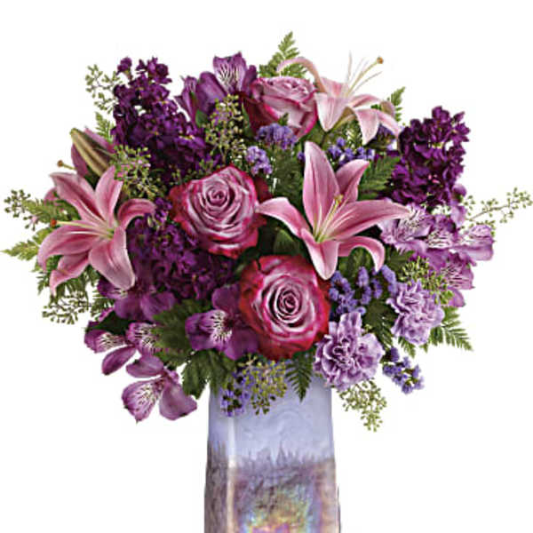 Pink and purple mixed bouquet in a tall iridescent vase