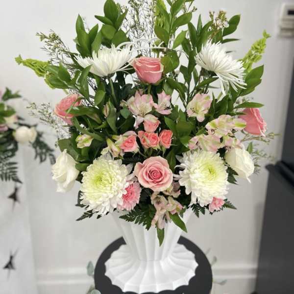 Pink and white flower arrangement in a white vase