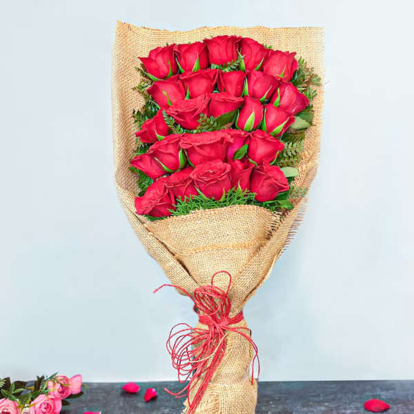 Bouquet of red roses wrapped in burlap with a red tie