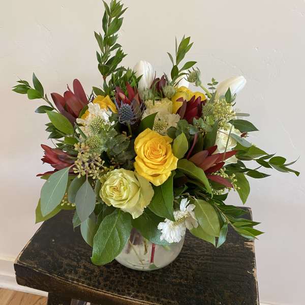 Mixed bouquet of yellow and white roses in a glass vase
