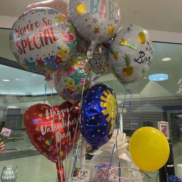 Cluster of birthday and baby-themed foil balloons indoors