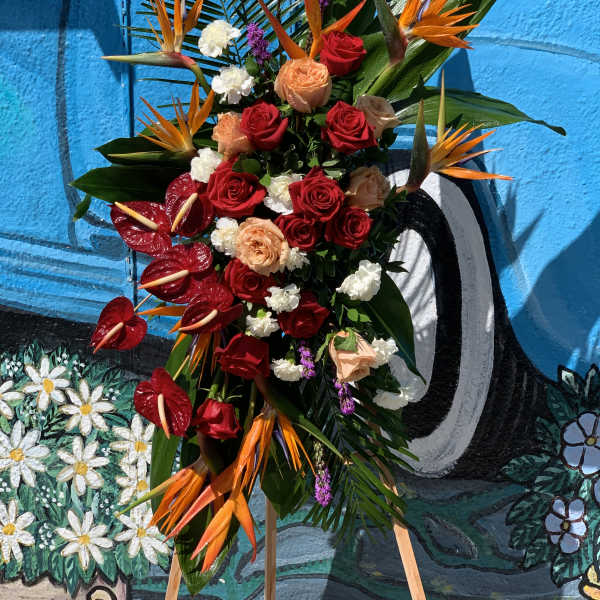 Tropical floral arrangement with red roses and orange bird-of-paradise flowers