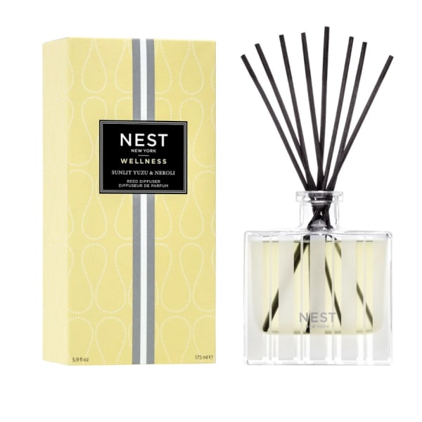 Yellow reed diffuser with black reeds beside its box