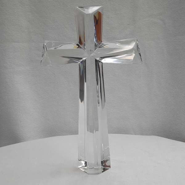 Clear glass cross ornament on a white surface