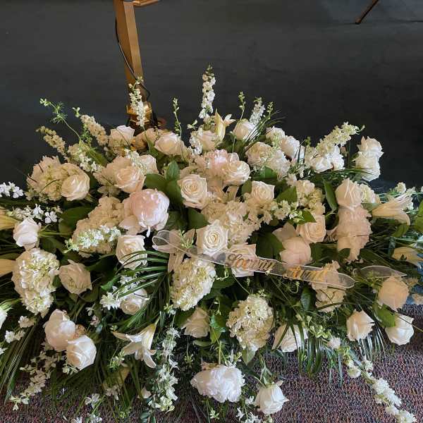 Large white floral spray with roses and lilies on the floor