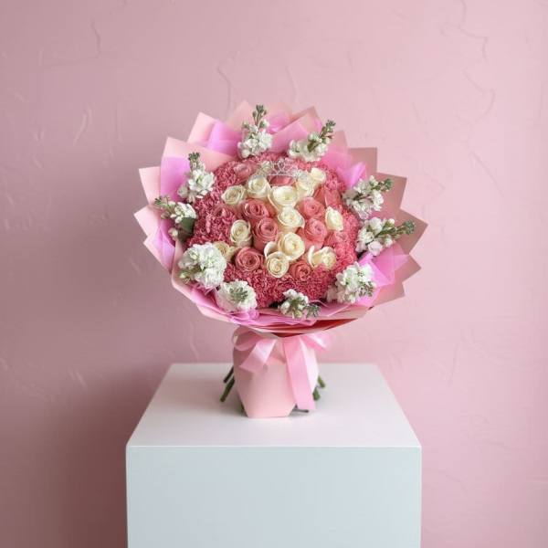 Pink and cream rose bouquet wrapped in pink paper