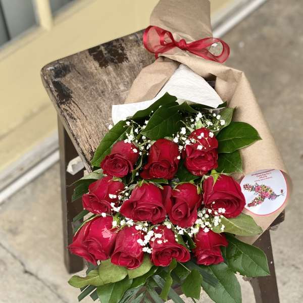 Bouquet of red roses wrapped in brown paper with a red ribbon