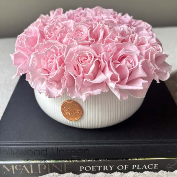 Pink rose arrangement in a white ribbed bowl