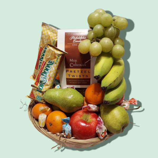 Fruit basket with grapes, bananas, pears, apples, oranges, and candy bars