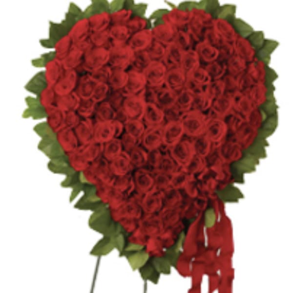 Heart-shaped red rose arrangement with a red ribbon