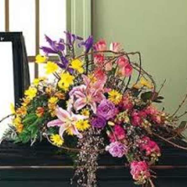 Colorful floral spray on a dark casket