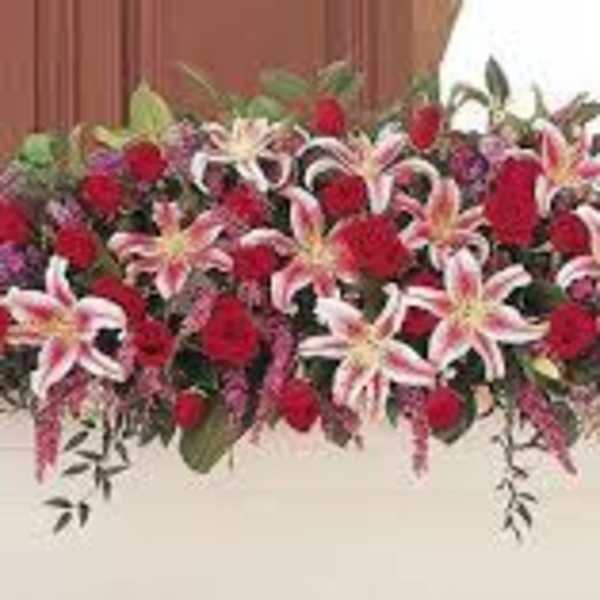 Long floral arrangement with red roses and pink lilies