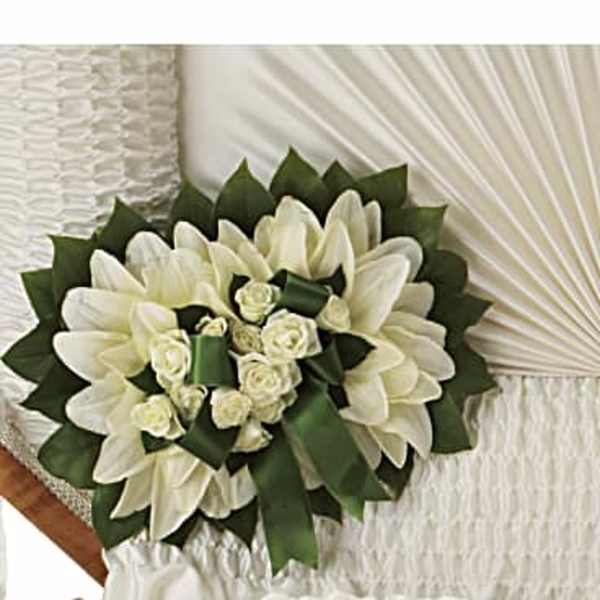 White floral bouquet with green ribbon accents on a white chair