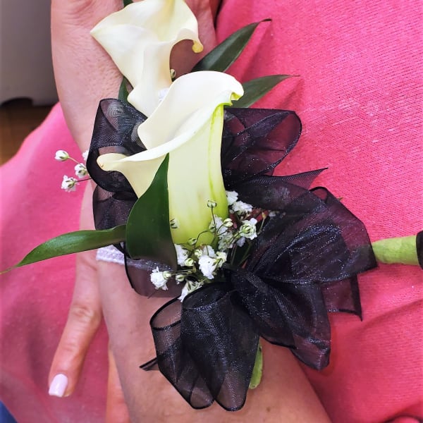 White calla lily corsage with black ribbon on a wrist