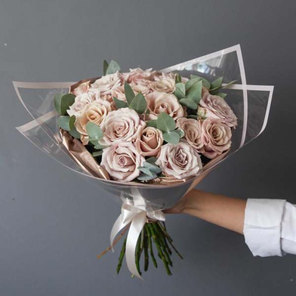 Handheld bouquet of pale pink roses with eucalyptus in clear wrap