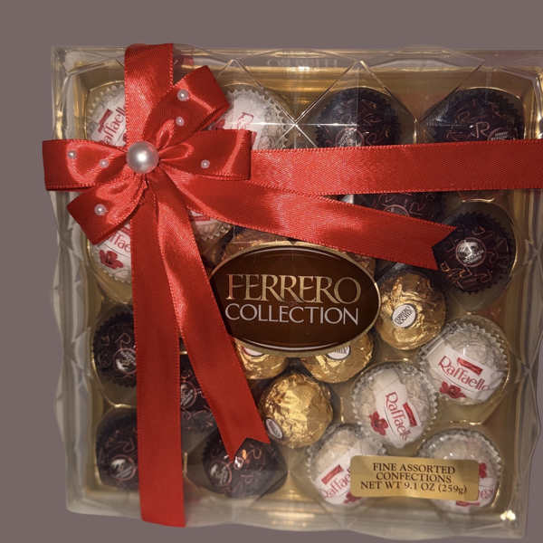 Assorted Ferrero Rocher and Raffaello chocolates in a clear gift box with a red ribbon