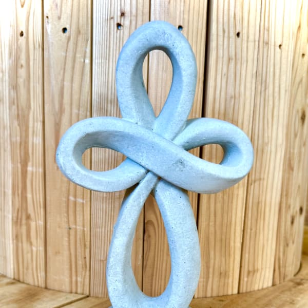 Blue decorative knot sculpture against a wooden background