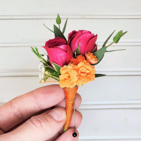 Small boutonniere with pink roses and orange flowers