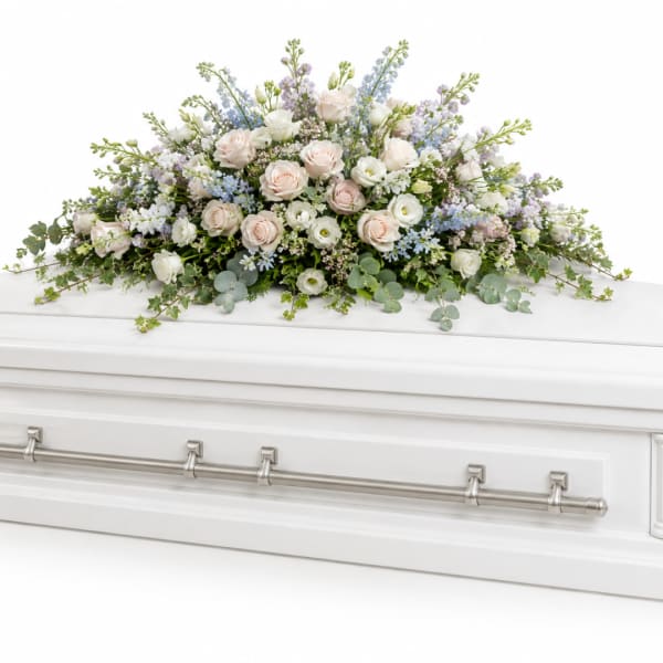 Pastel floral spray on a white casket