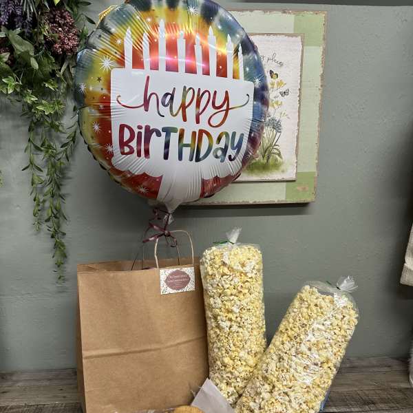 Birthday balloon with snack gift bag, popcorn, cookies, and candy